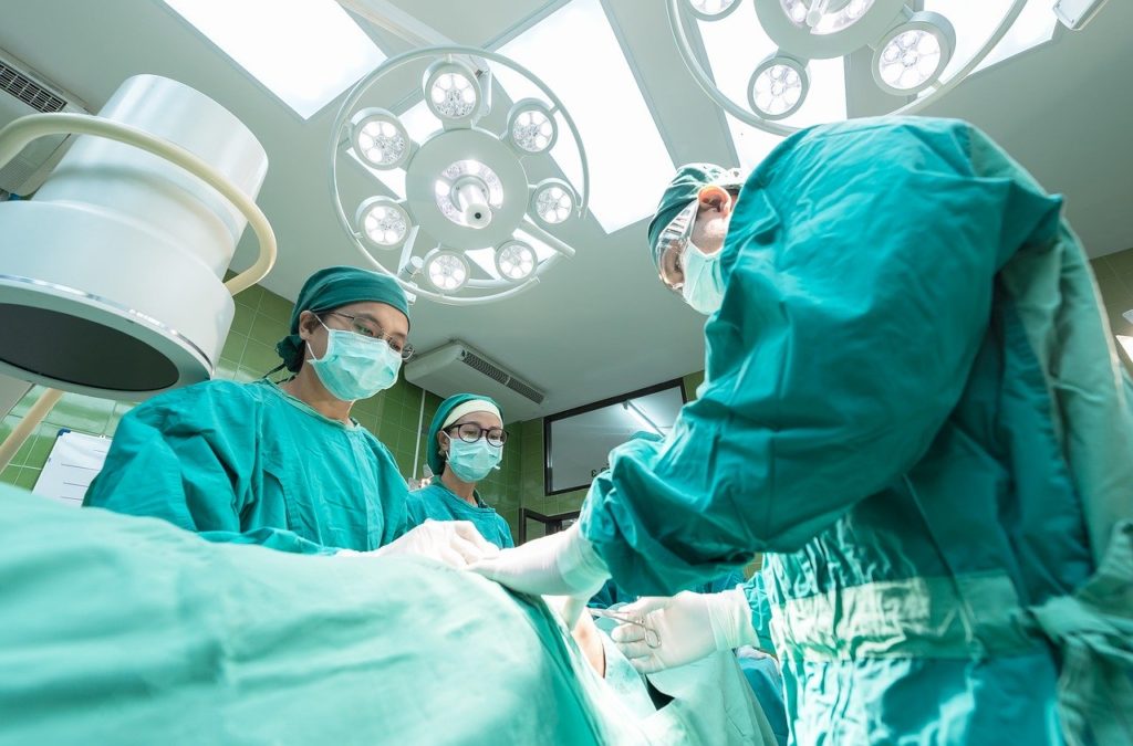 Ärzte und Chirurgen bei einer Operation mit Masken in Krankenhaus